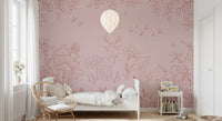 Pink floral and deer wall mural in a kids bedroom with a simple white bed.