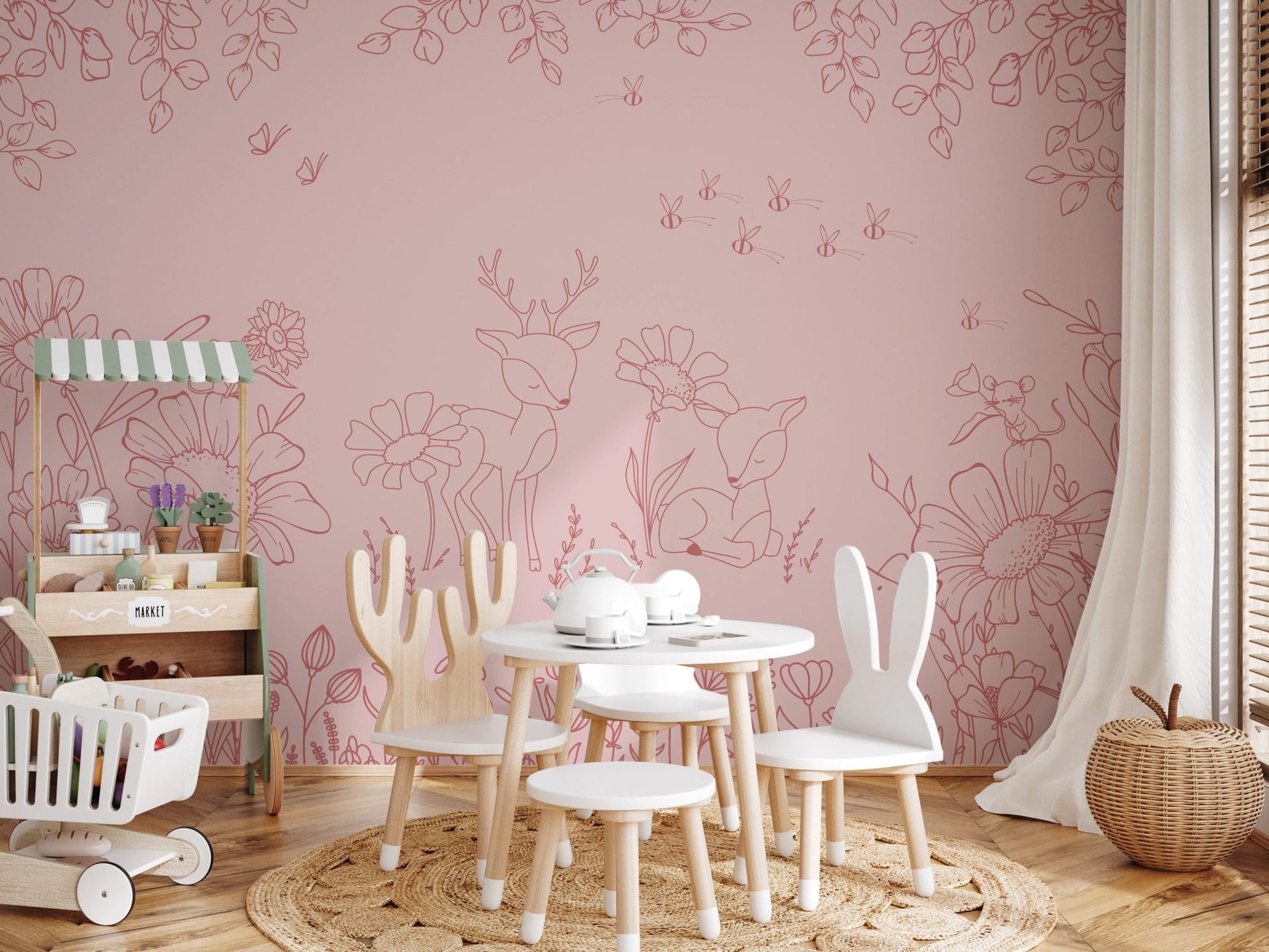 Nature themed pink wall mural in a nursery with a white rabbit-eared chair.