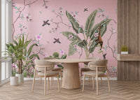 Pink floral dining room wall mural with banana leaves and monkeys around a wooden table.