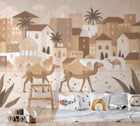 Nursery wall mural with a desert village scene behind a light wood crib.