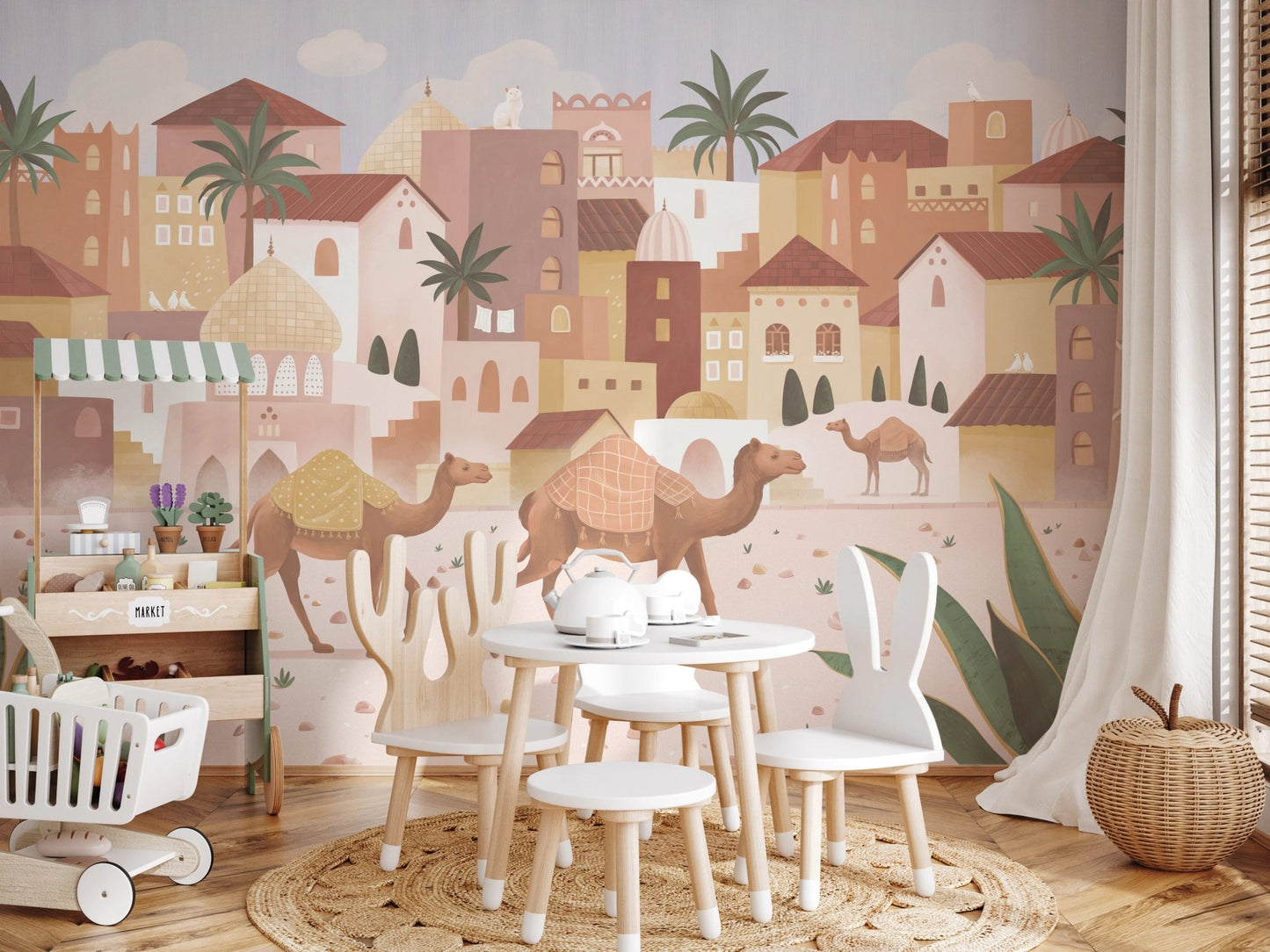 Children’s seating area with a desert-themed wall mural and white wooden chairs.