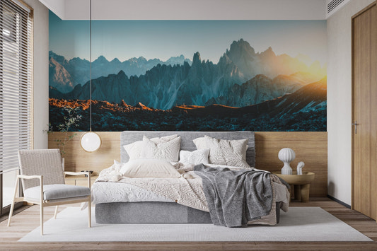 Minimalist bedroom featuring a blue mountain wall mural behind a grey bed.