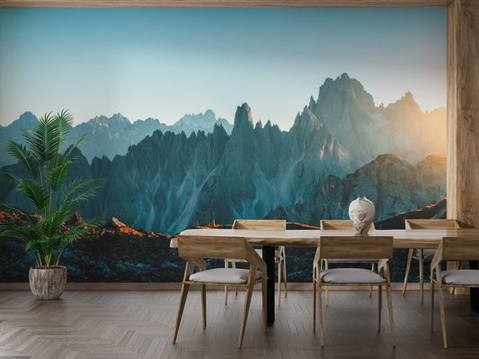 Dining space with wood furniture and a sunset mountain wall mural backdrop.