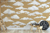 Dreamy sky birds wall mural with white clouds on mustard wallpaper.