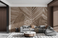 Earthy brown botanical wall mural with large leaf patterns in bright living area.