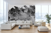 Bright living room with a red cushion on the sofa and a dark grayscale wall mural.
