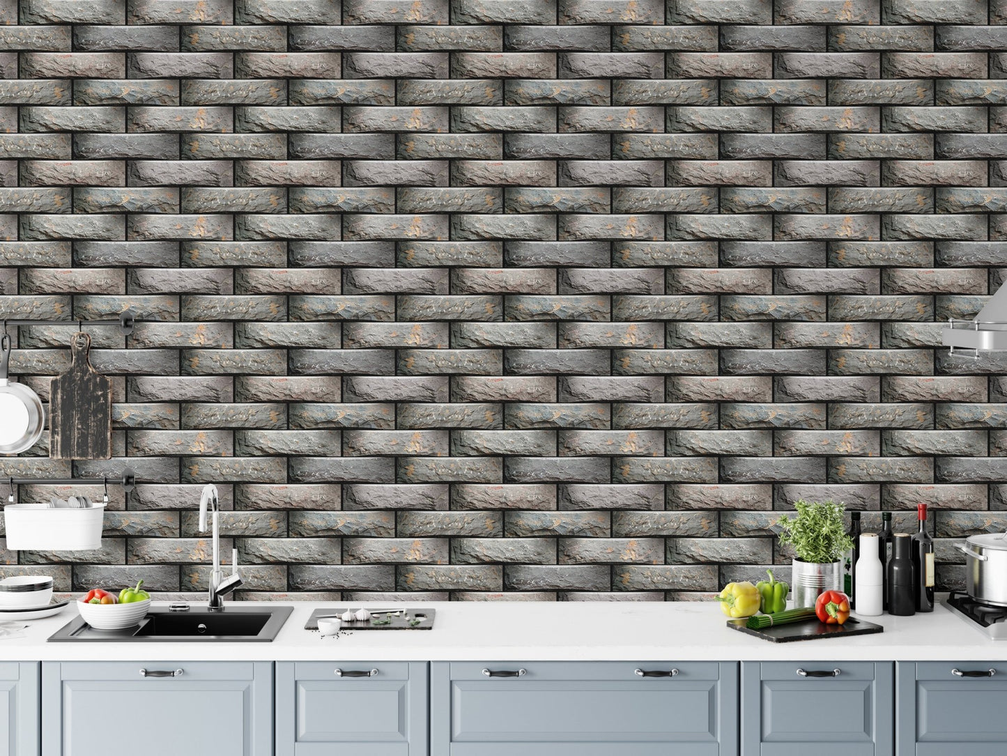 Kitchen area with grey brick effect wallpaper above a white counter.