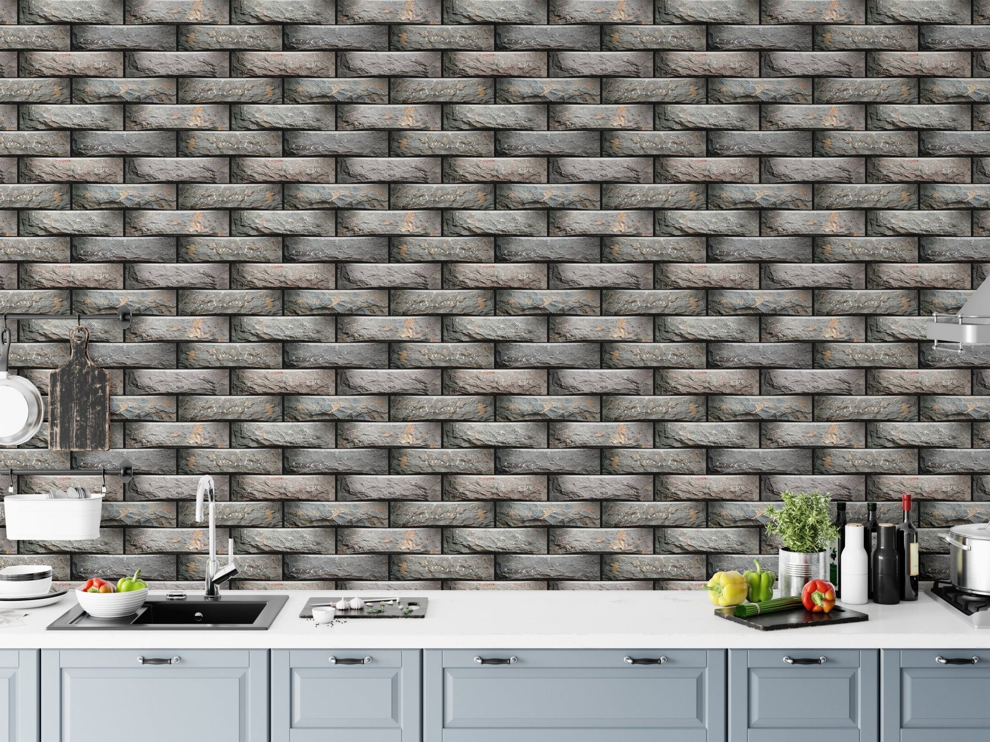 Kitchen area with grey brick effect wallpaper above a white counter.
