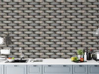 Kitchen area with grey brick effect wallpaper above a white counter.