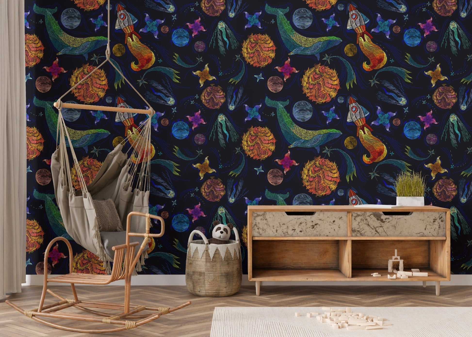 Embroidery inspired space adventure wallpaper in a room with a wooden rocking chair.