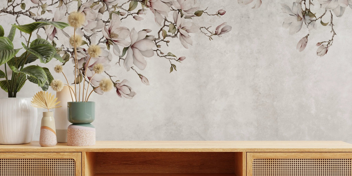Wooden sideboard with potted plants in front of a blossoms wall mural.