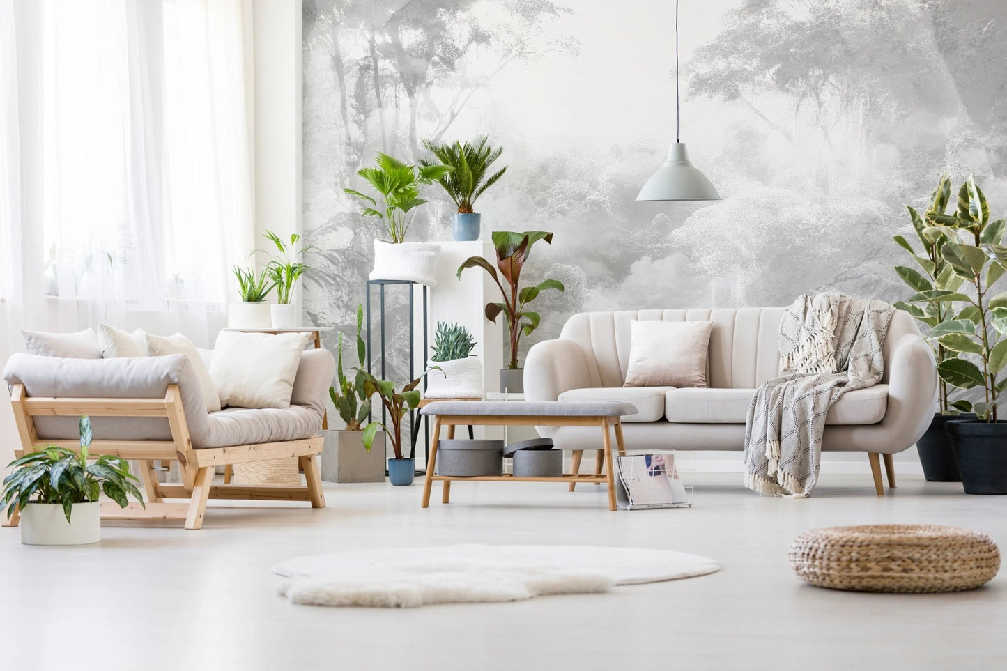Sunlit sitting room with grey jungle wall mural and armchairs.