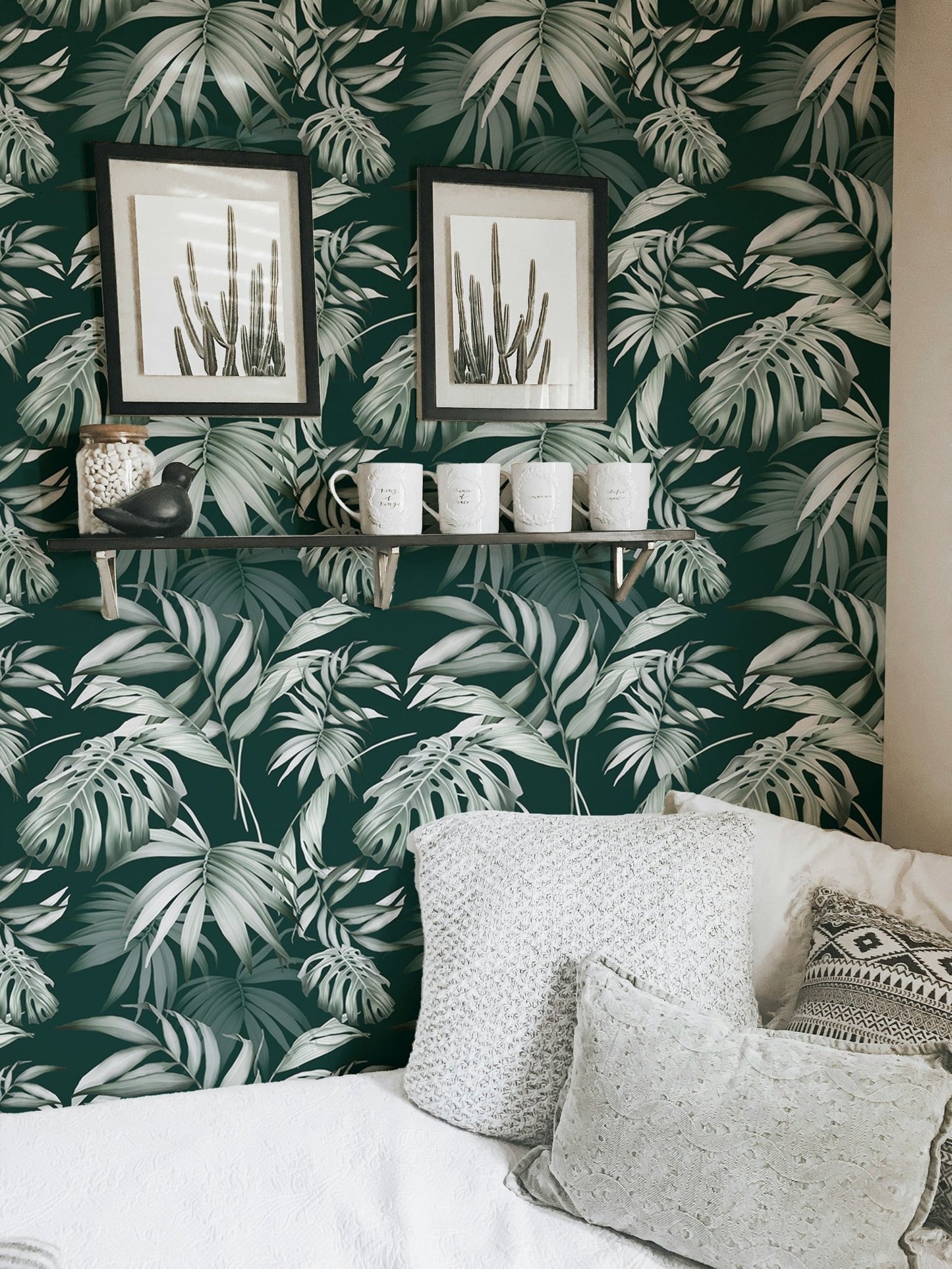 Dark green jungle wallpaper in a seating area with white cushions and frames.