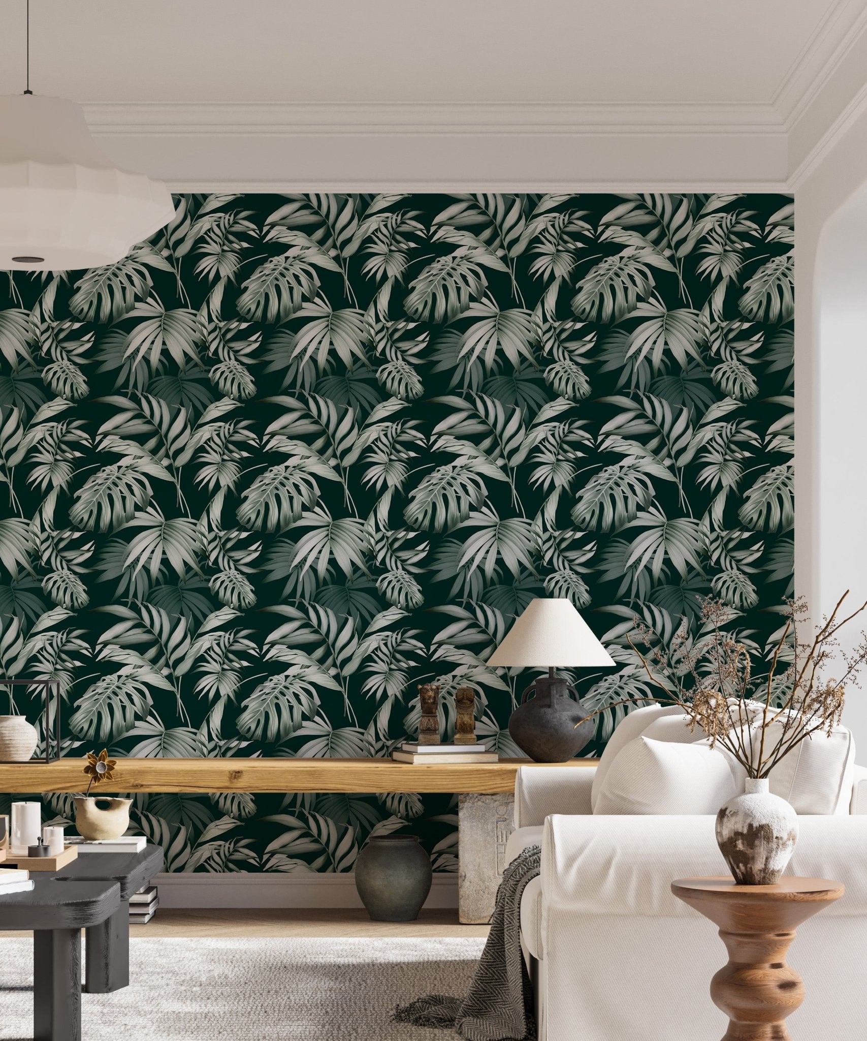 Dark green leaf wallpaper in a living space with a white sofa and desk.