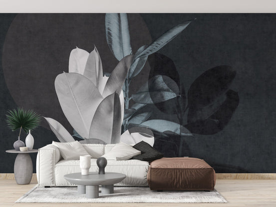 White sofa and brown ottoman with dark botanical leaf wall mural.