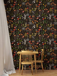 Small wooden dining table set against a dark mushroom and flower wallpaper.