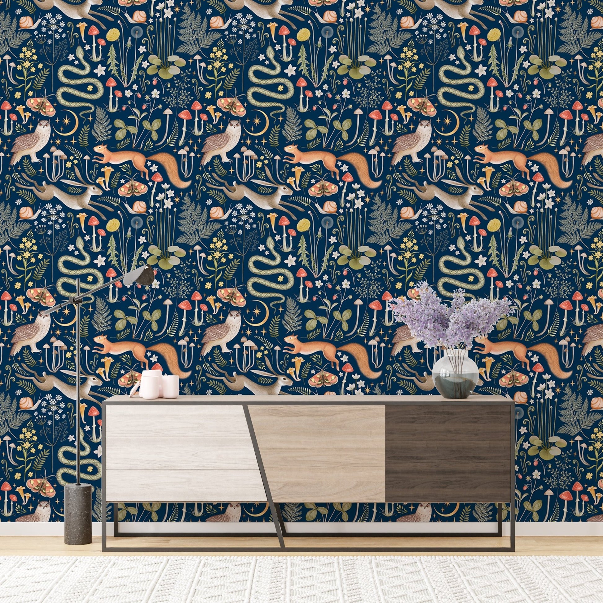 Woodland creature wallpaper on dark blue backdrop above a modern sideboard.