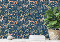 Dark blue wallpaper featuring forest animals behind a green potted plant.