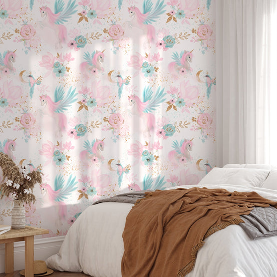 Pink wallpaper with blue unicorn illustrations behind a bed with brown linens.