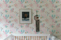 Pink and blue wallpaper pattern used as a backdrop for a white bed frame in kids bedroom.