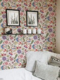 Framed art on floral jacobean wallpaper in a cozy seating area.