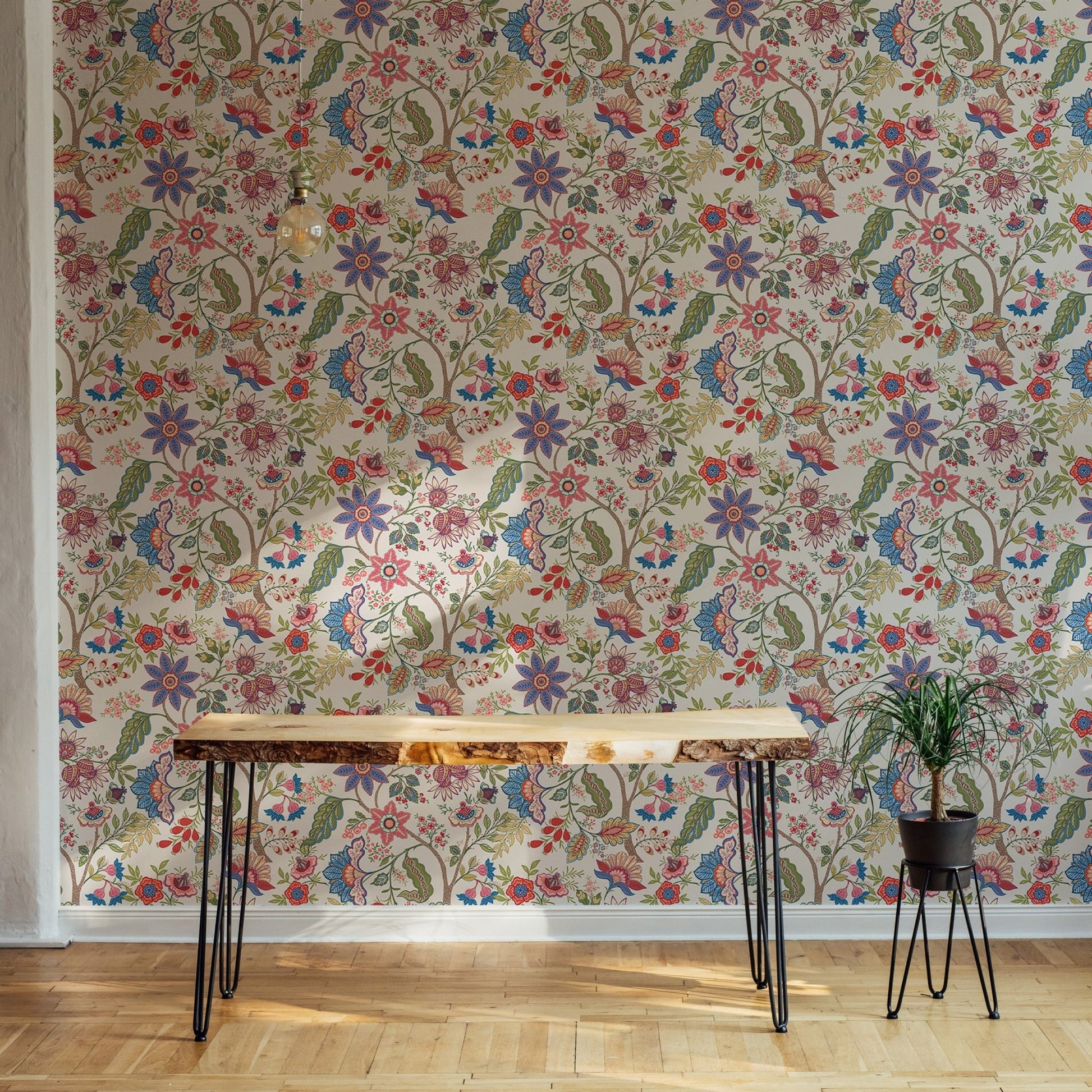 Minimalist wooden desk against a full wallpaper of vintage fantasy flowers.