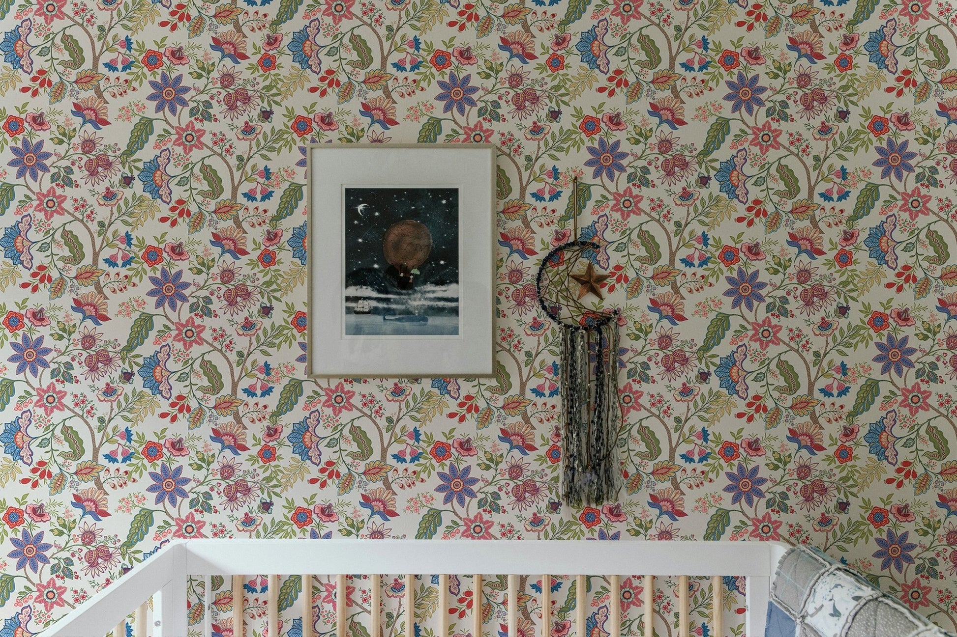 Nursery crib against fantasy flowers retro vintage jacobean embroidery style wallpaper.