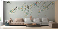 Modern living area with white seating and nature-inspired canopy wall mural.