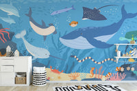 Sea life wall mural in a playroom featuring white storage cabinets.