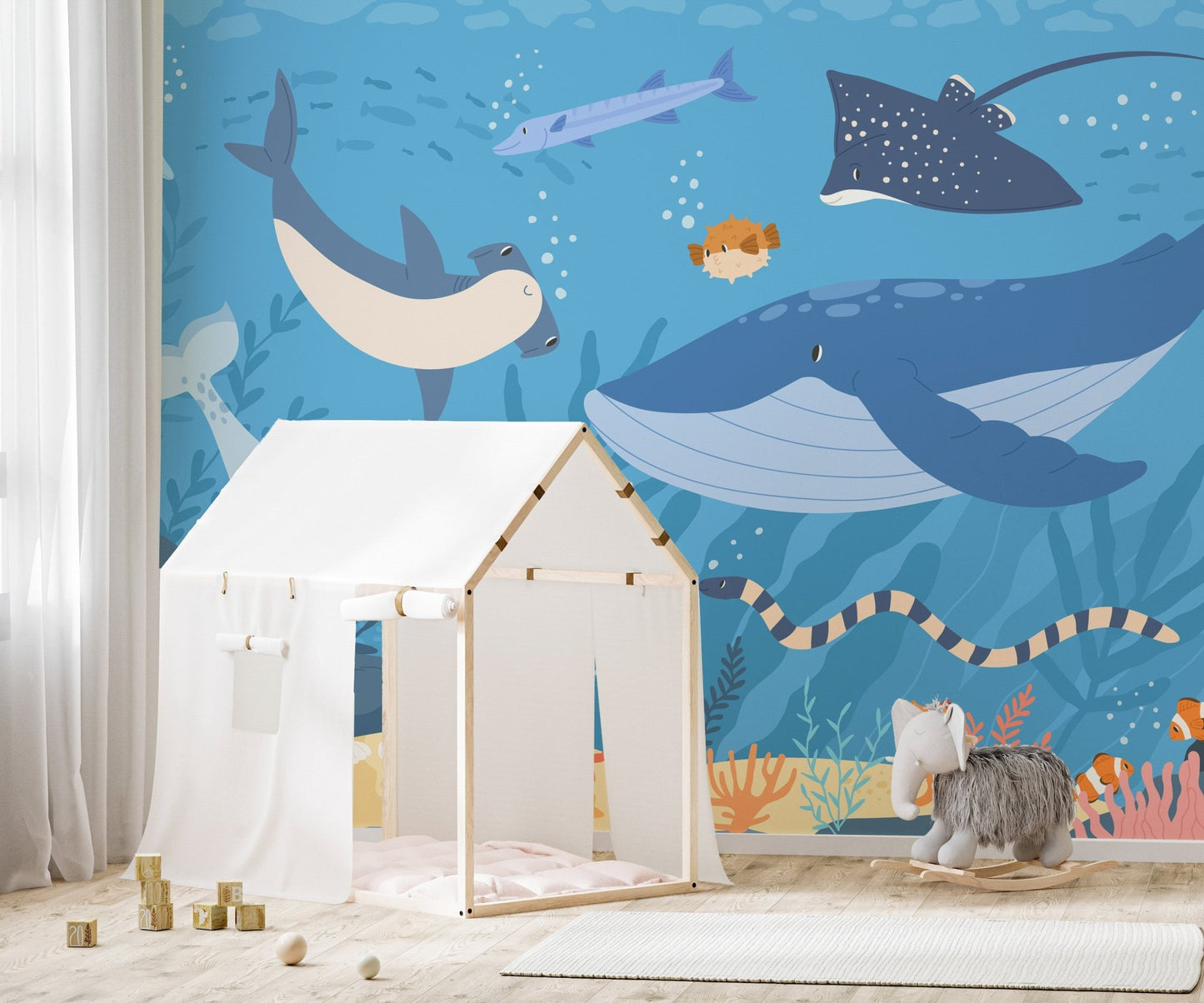 Whale and marine life wall mural behind a white wooden playhouse tent.