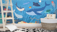 Sea life wall mural in a kids room featuring a wooden ladder and basket.