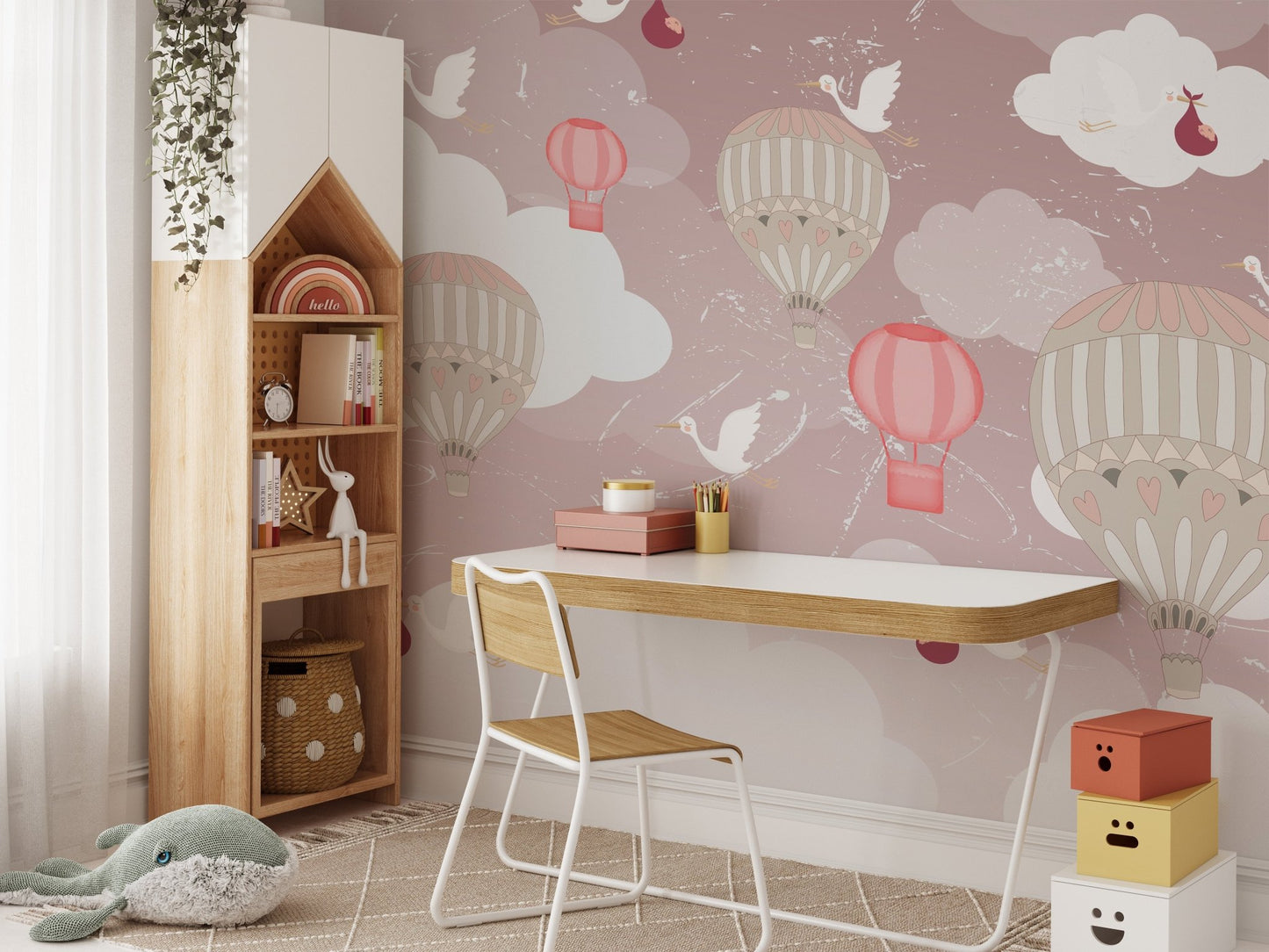 Kids study area featuring balloon wall mural and a wooden desk with white chair.