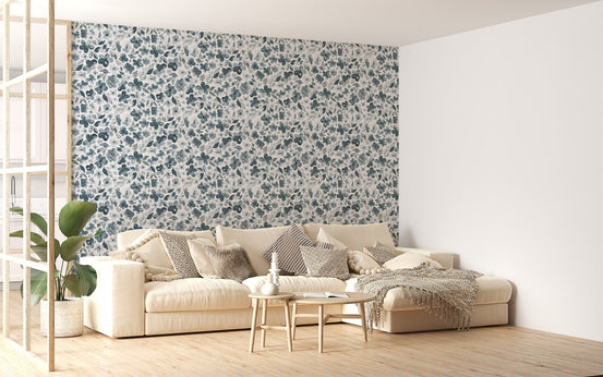 Floral bluish grey wallpaper in a large living room with a cream-colored sofa.