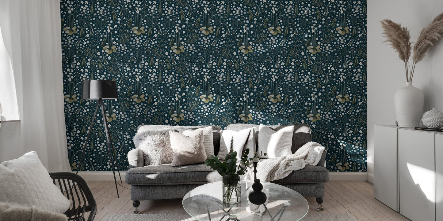 Navy blue leaf pattern wallpaper in a living room with a grey sofa and floor lamp.