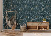 Botanical leaves wallpaper in a nursery with a hanging wicker chair and wooden floor.