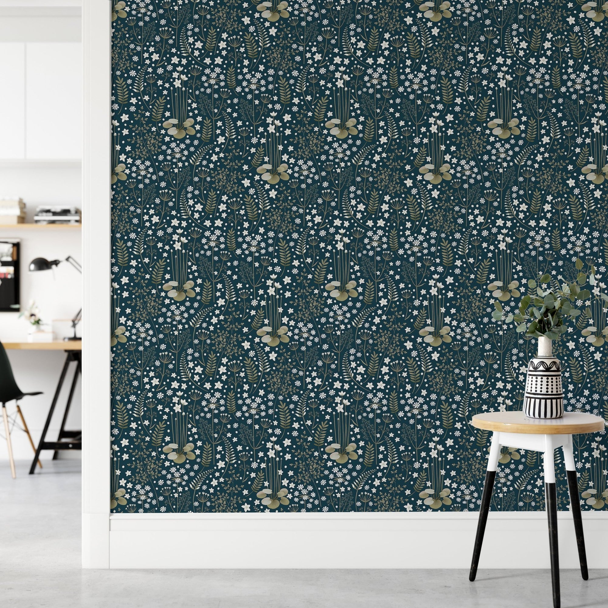 Floral dark blue background leaves removable wallpaper in a hallway with a white stool.