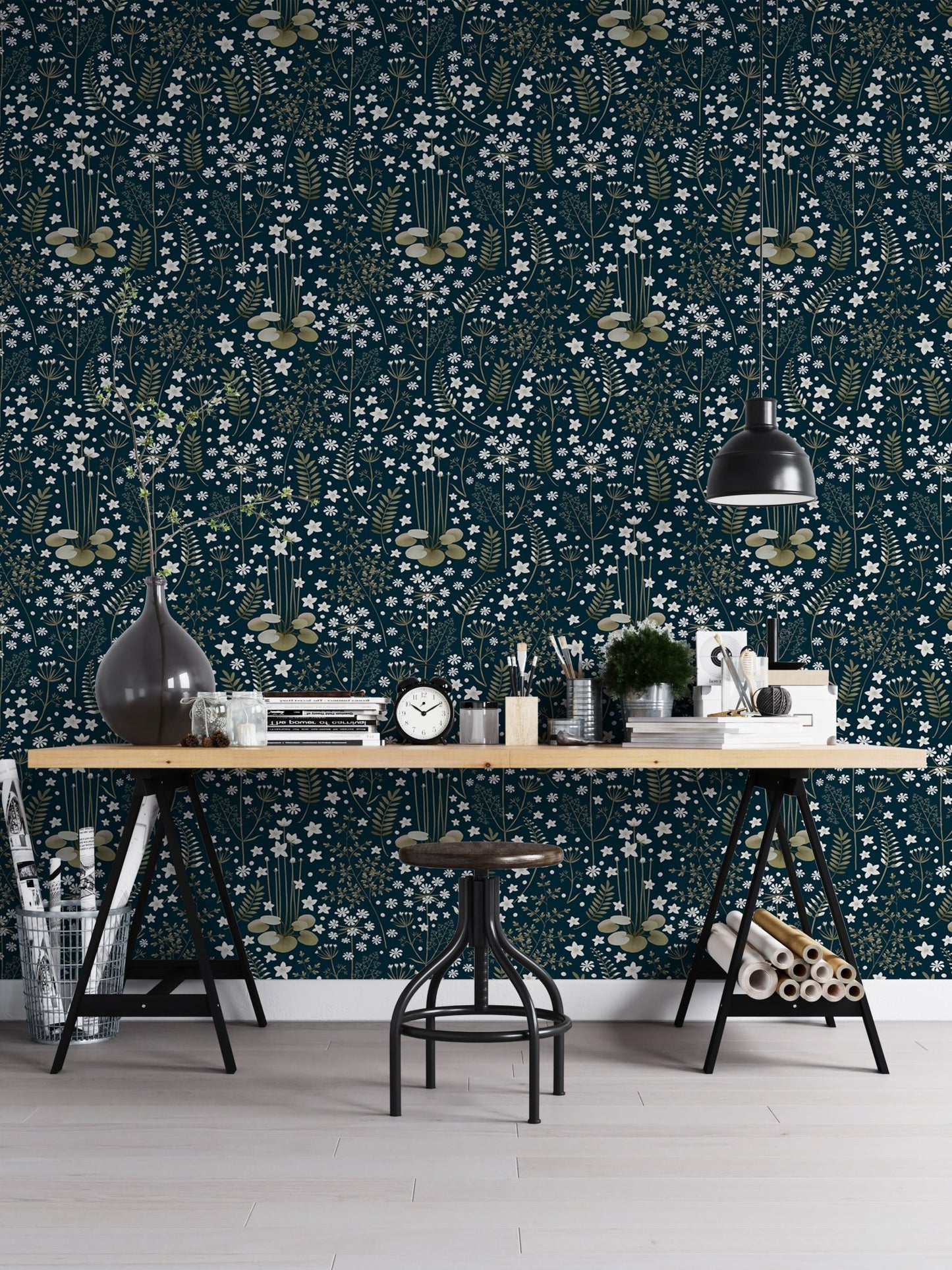 Botanical leaves pattern wallpaper behind a minimalist black desk in a home office.