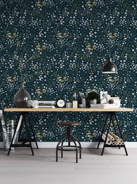 Botanical leaves pattern wallpaper behind a minimalist black desk in a home office.
