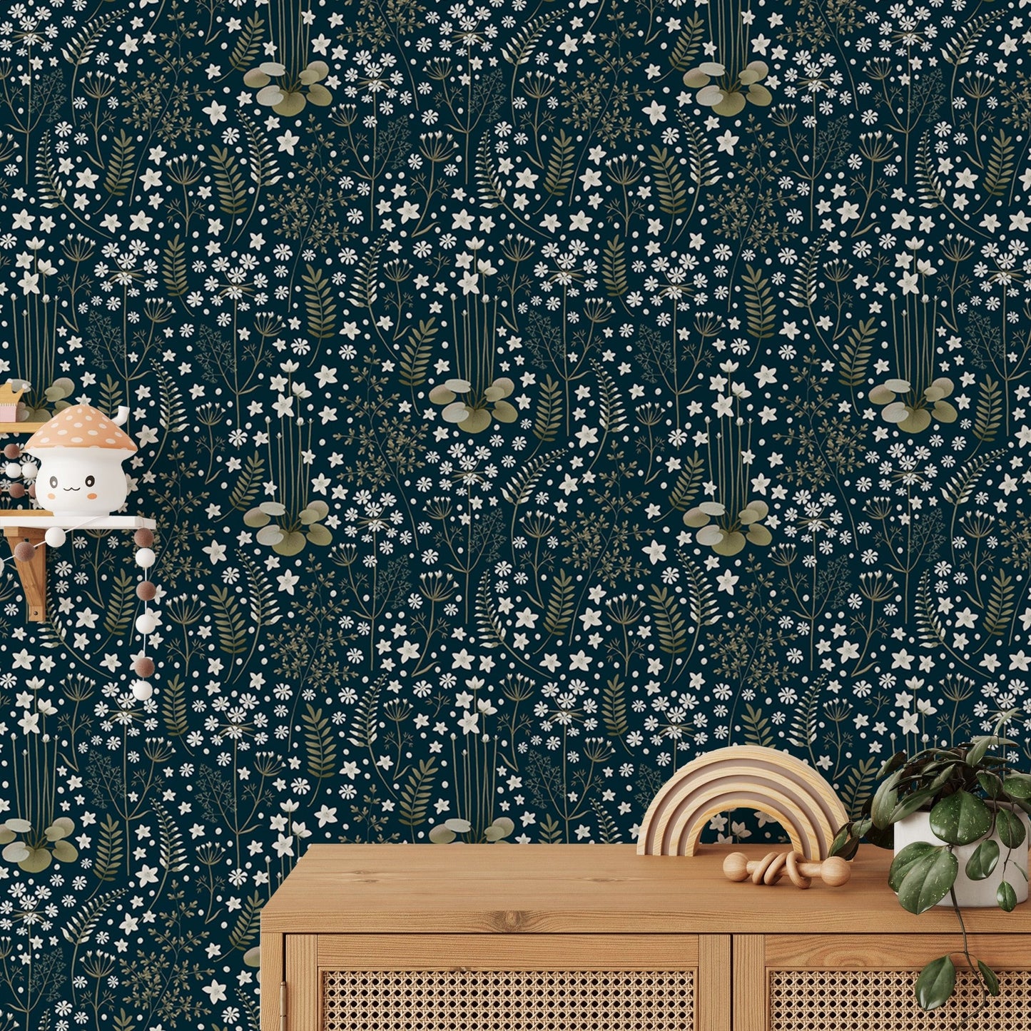 Botanical leaves wallpaper behind a wooden cabinet with small decor items.