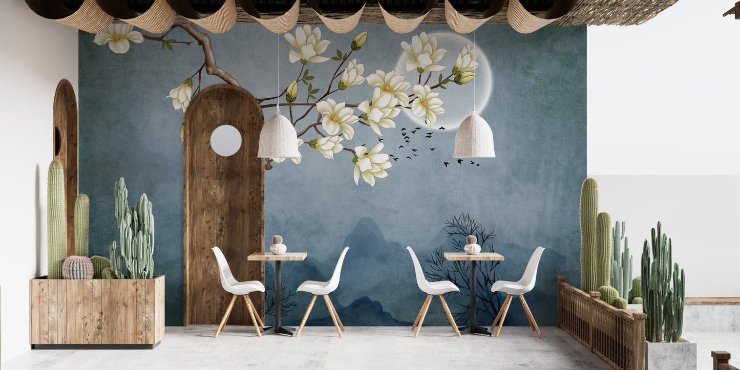 Wall mural with magnolia branches and a moon printed behind a wooden dining set.