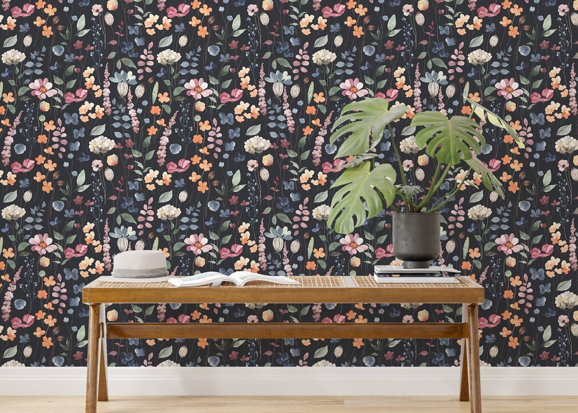 Dark blue floral wallpaper behind a wooden bench with a green monstera plant.