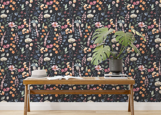 Dark blue floral wallpaper behind a wooden bench with a green monstera plant.