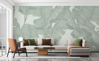 Tropical banana leaf pattern wall mural with a white sofa and wooden coffee table.
