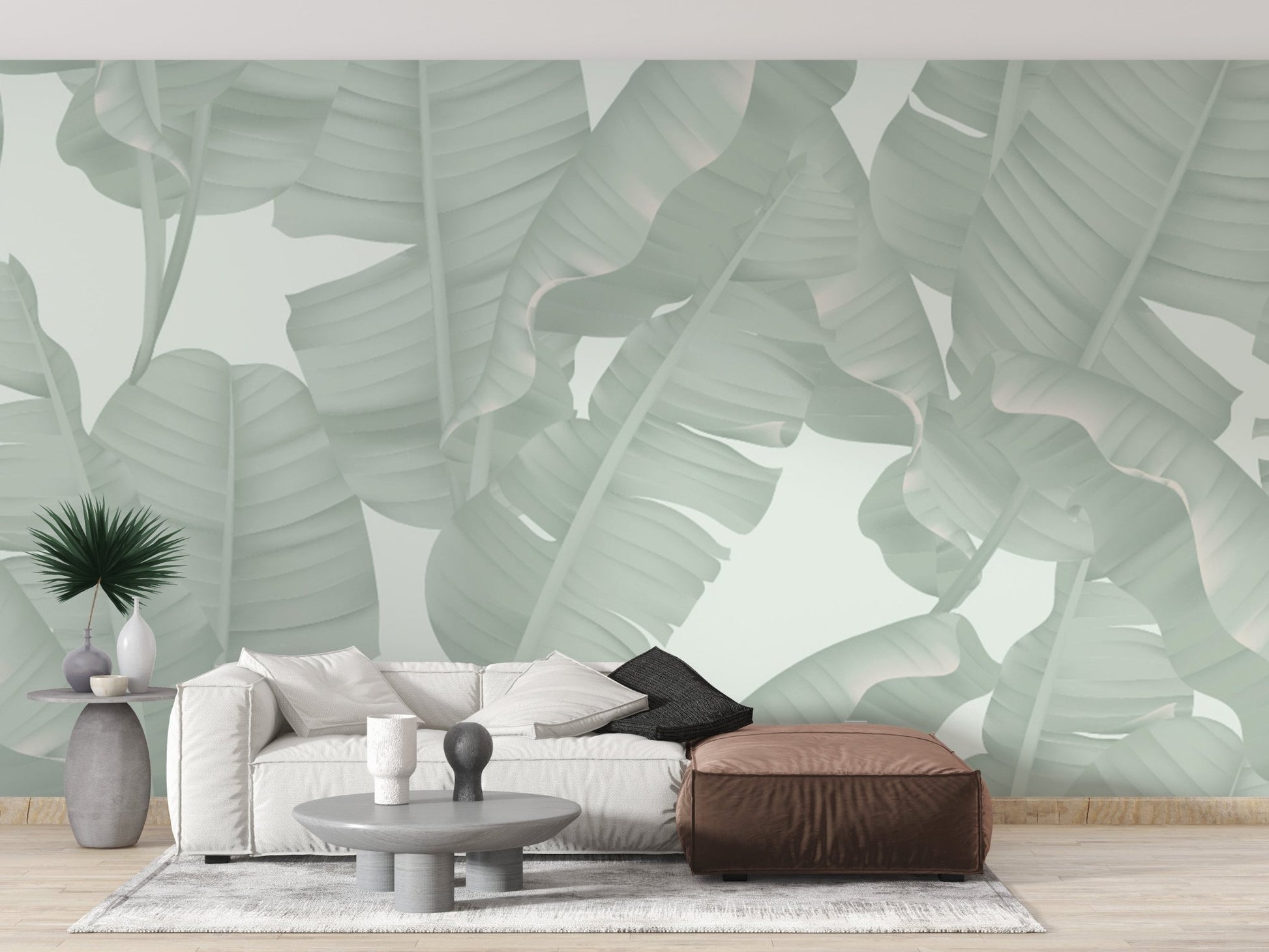 Large scale banana leaf wall mural in a minimalist living room with neutral tones.
