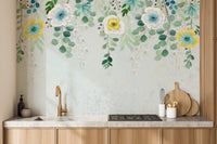 Kitchen interior with light wood cabinetry and a green blossoms  wall mural.
