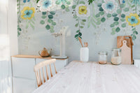 Wooden kitchen table set against a leafy botanical blossoms wall mural.
