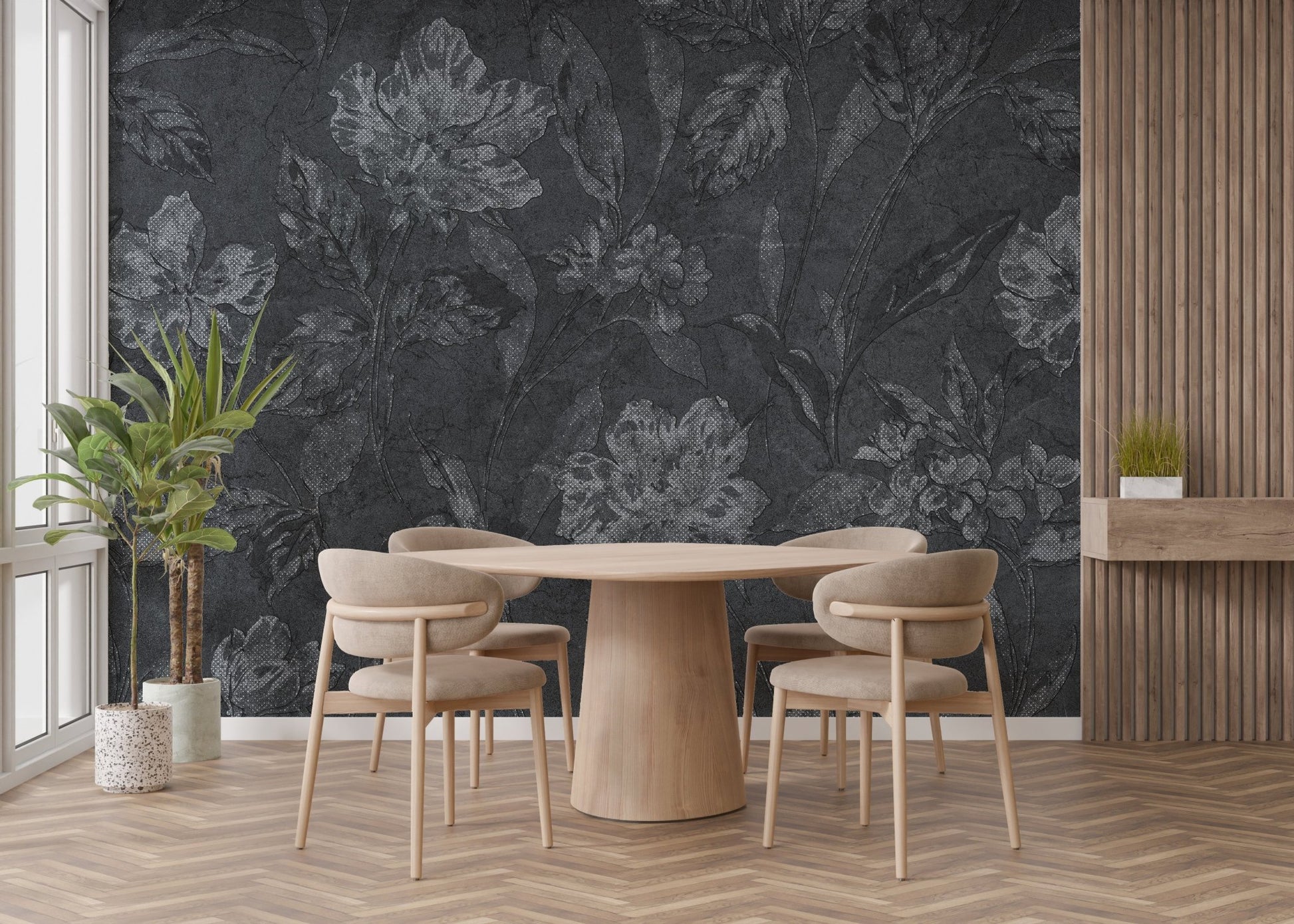 Dark floral pattern wallpaper behind a round wooden table and minimalist chairs in a sunlit room.