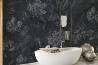Black floral pattern wallpaper highlighting a sleek white sink in a minimalist washroom area.