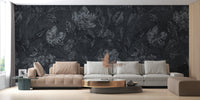 Large scale flower wallpaper behind a low profile grey sofa in a contemporary lounge.