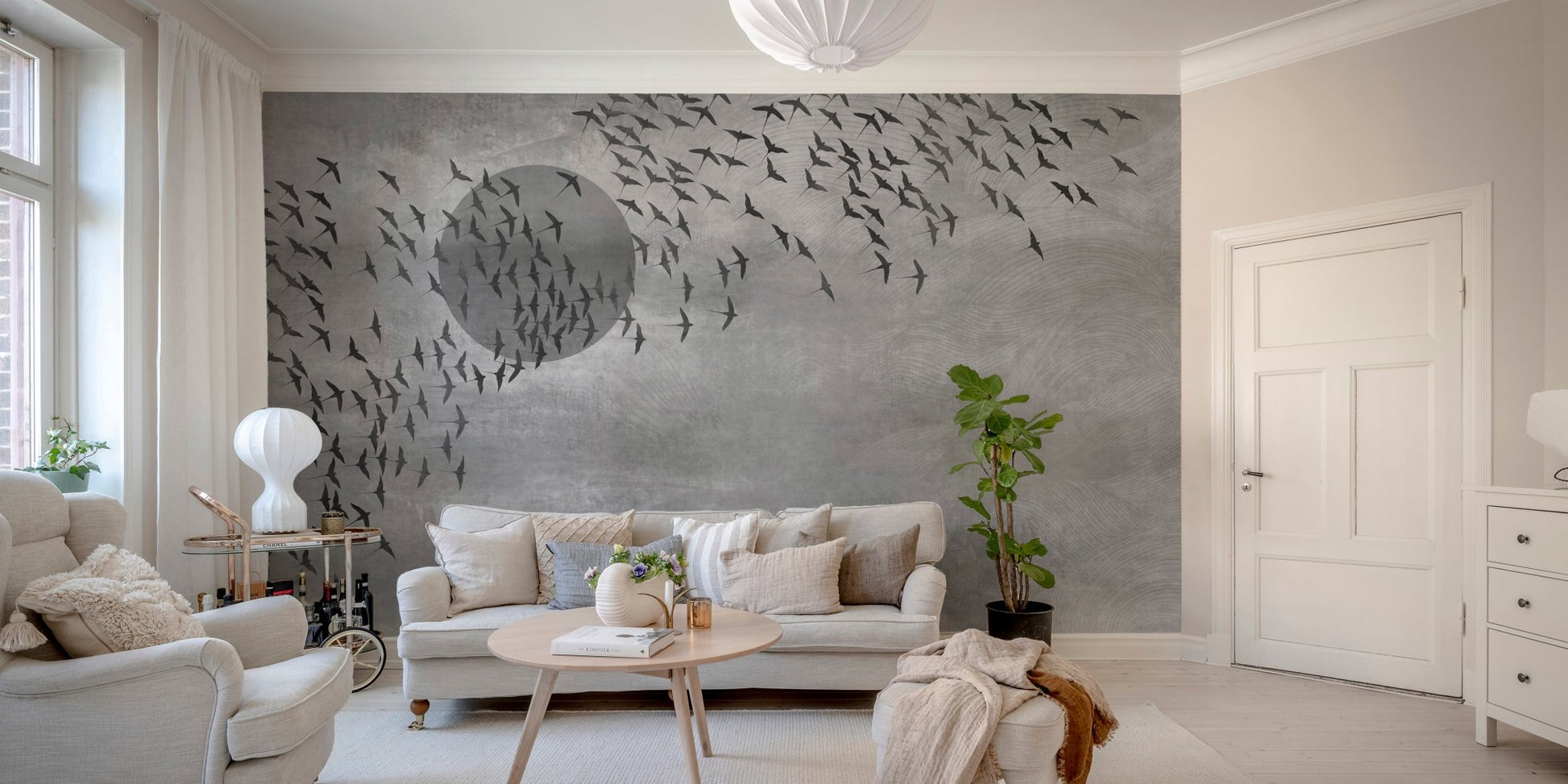 Flying birds wall mural installed behind a white sofa in a minimalist living room.